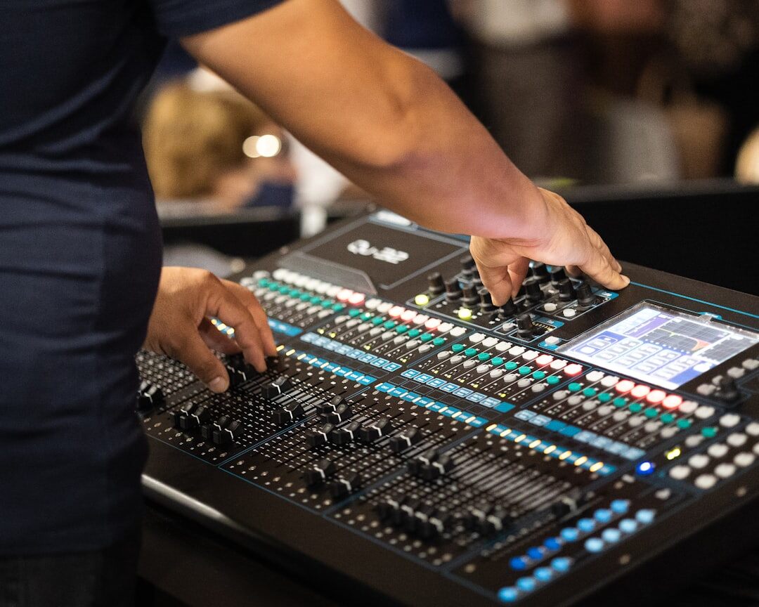 Close-up of hands operating a professional video vision mixer switcher panel